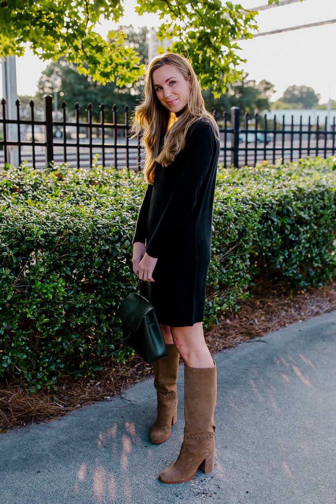 woman wearing black sweater dress with knee high boots