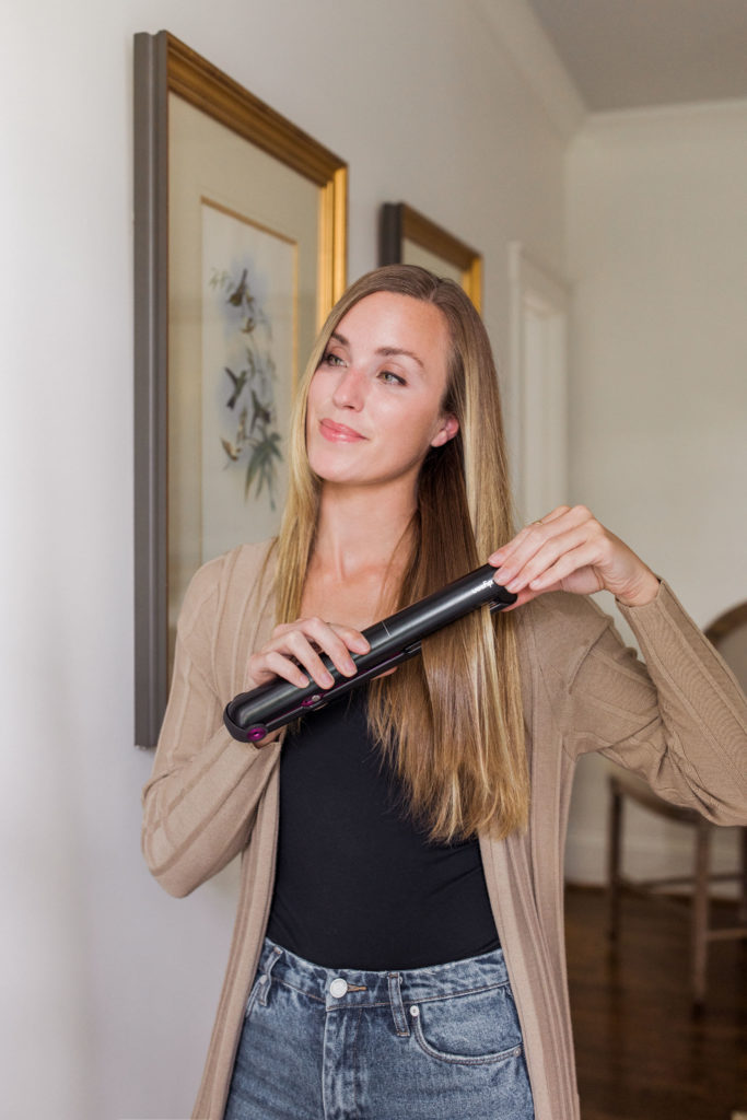 dyson corrale straightener being used on long hair