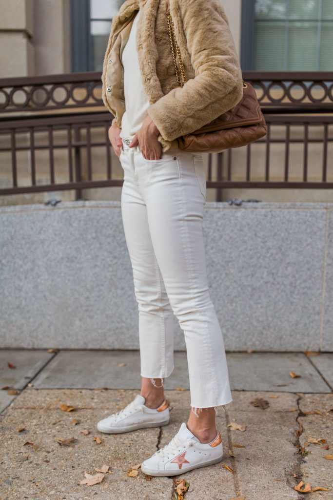 white and gold golden goose superstar sneakers outfit with white jeans and fur coat