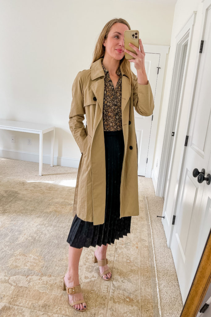pleated midi skirt outfit for spring with trench coat, floral blouse, black pleated midi skirt, and heeled sandals