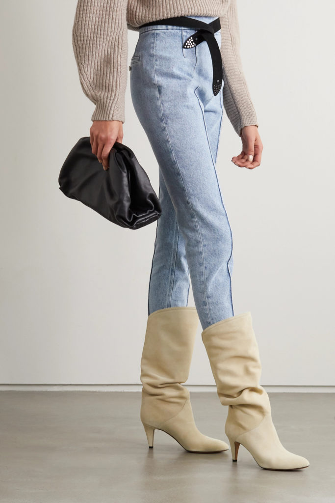 woman wearing white cowboy boots with light jeans and oversized sweater