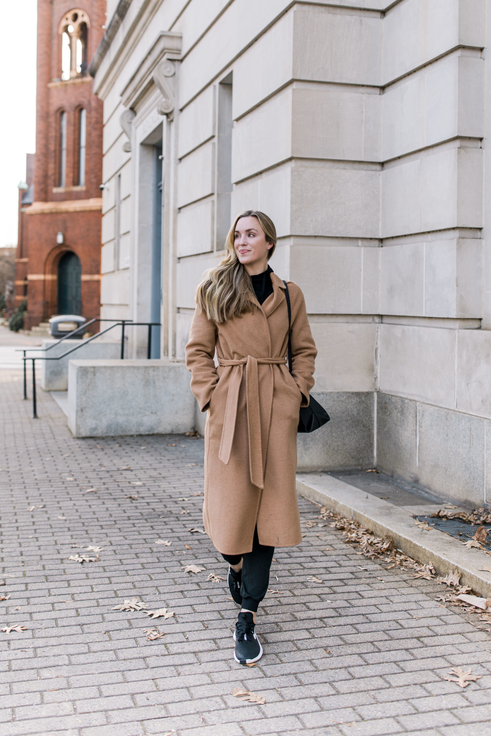 woman wearing comfy casual winter outfit with mango camel coat lululemon joggers and nike sneakers