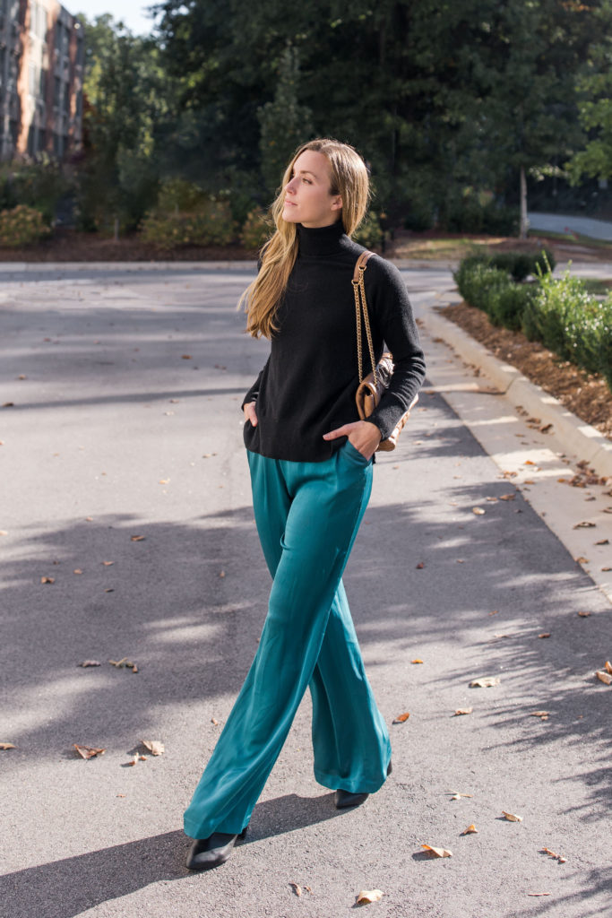 woman wearing dressy turtleneck outfit with black oversized turtleneck and teal silk pants