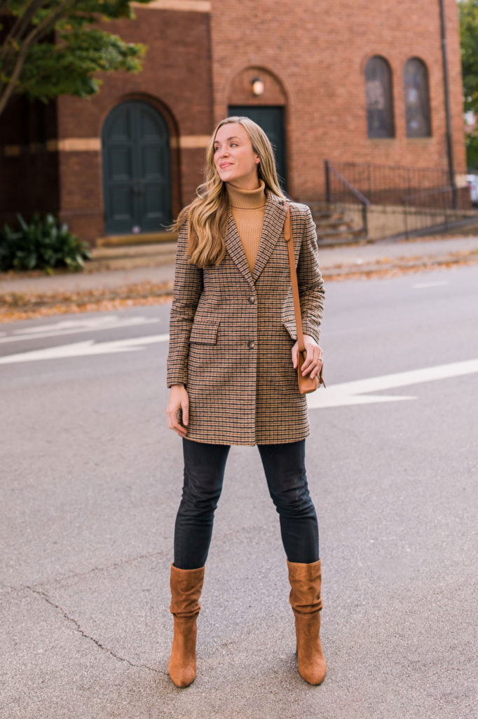 woman wearing tan turtleneck with plaid blazer coat black levis and brown mid calf boots