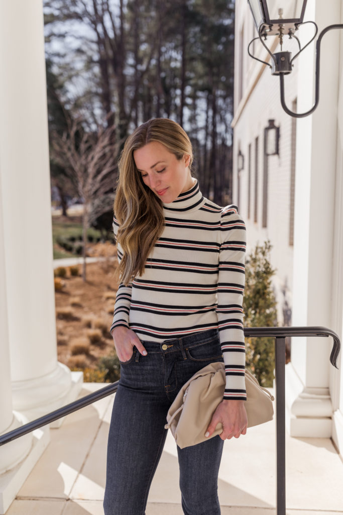 striped sweater valentines day outfit with clutch and flare jeans