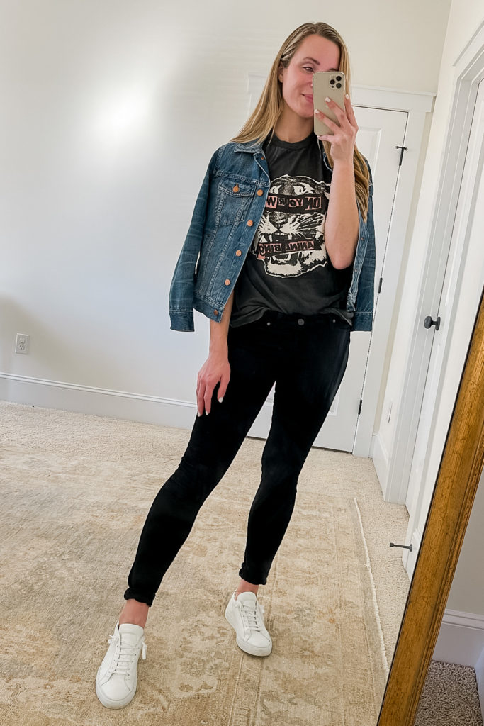 black jeans outfit idea with jean jacket graphic tee and white sneakers