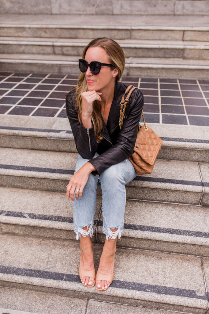 black leather jacket with light blue jeans and heeled sandals