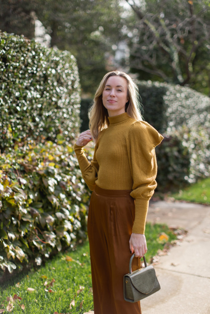 natalie yerger wearing earth tone outfit with mustard sweater and hazelnut silk pants