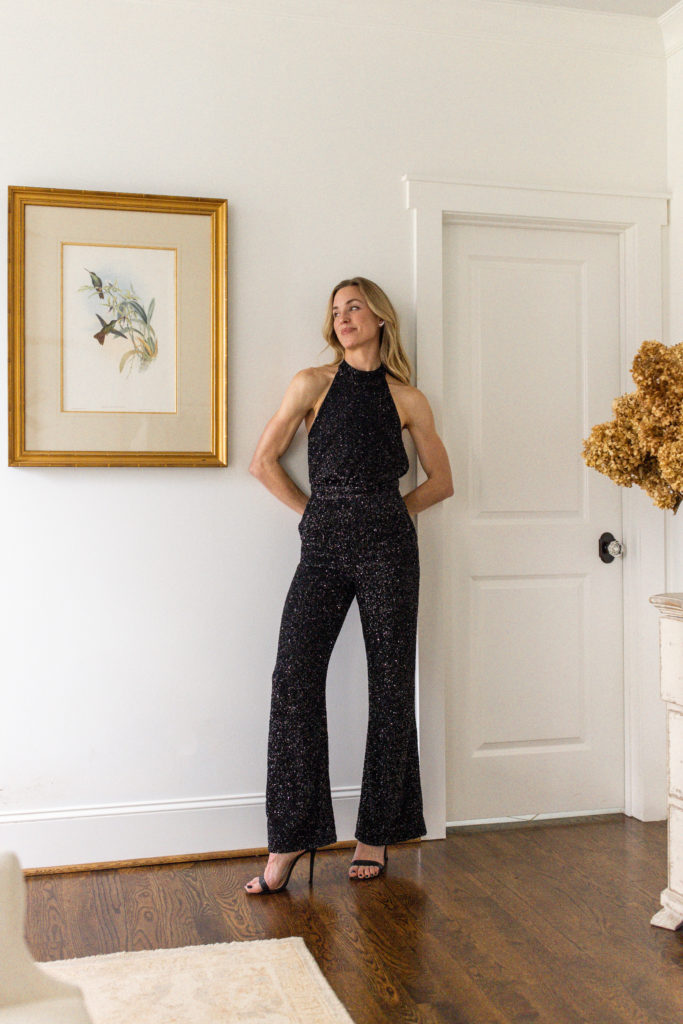 Natalie Yerger dans une tenue de fête abordable, une combinaison à paillettes et des talons hauts noirs.